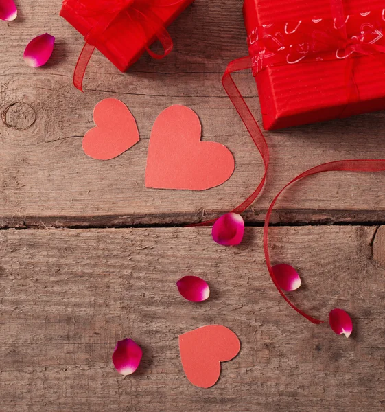 Valentinstag-Geschenkbox und rote Herzformen auf Holzbrett — Stockfoto