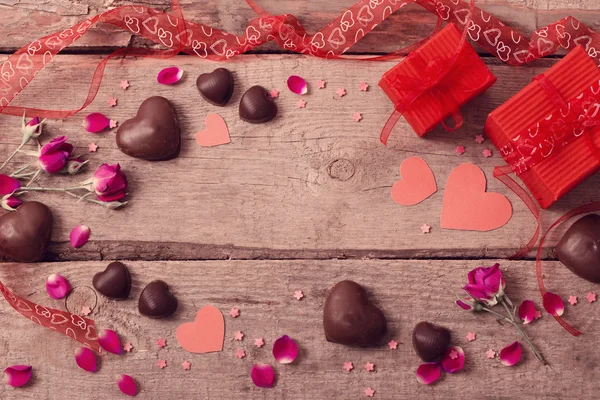 Caja de regalo de San Valentín y formas de corazón rojo en tablero de madera —  Fotos de Stock