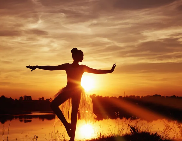 Silhueta de uma dançarina de balé ao pôr-do-sol ao ar livre — Fotografia de Stock