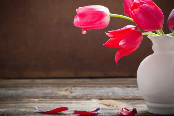Red tulips on old dark background — Stock Photo, Image