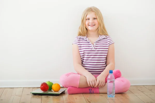 Happy girl  with scales and fruits — Stock Photo, Image