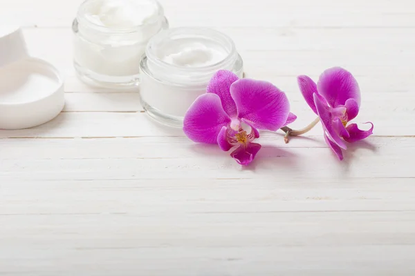 Fiori di orchidea crema e rosa su sfondo di legno bianco — Foto Stock