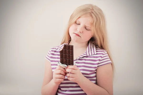 Menina preocupada comer chocolate — Fotografia de Stock