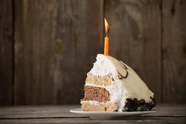 Kawałek tortu urodzinowego na drewniane tła — Zdjęcie stockowe