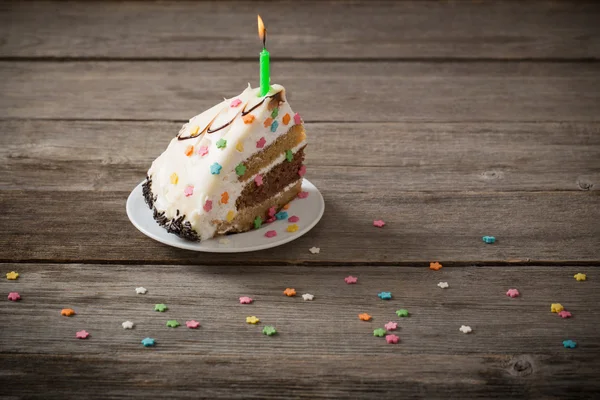 Pezzo di torta di compleanno su sfondo di legno — Foto Stock