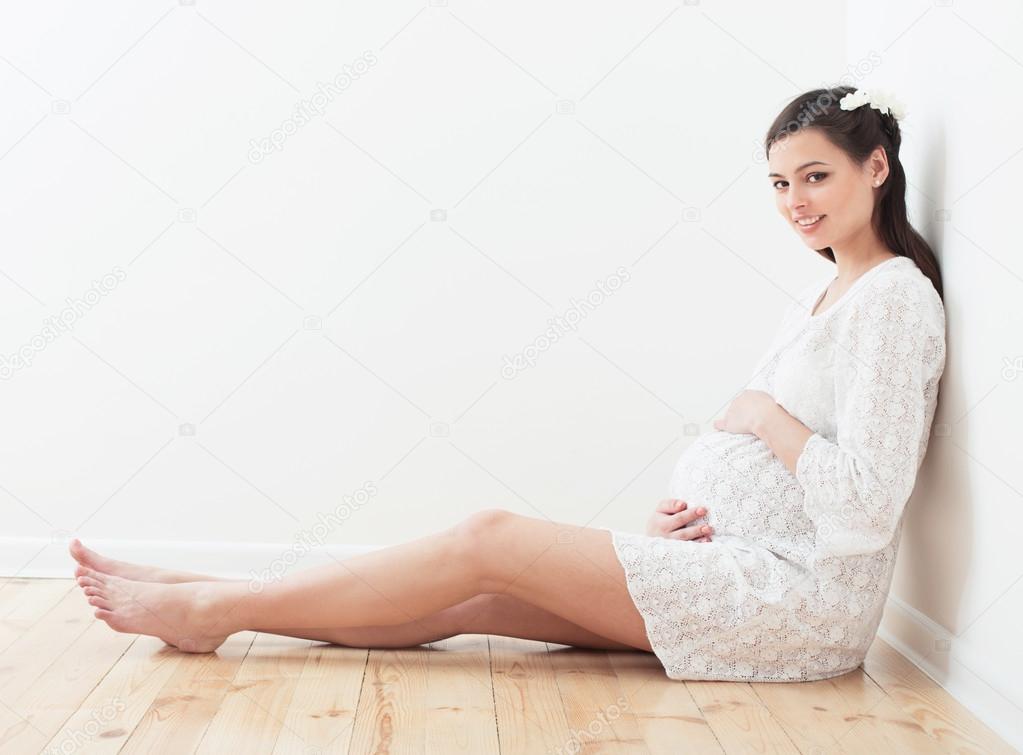 happy pregnant women sitting on the floor