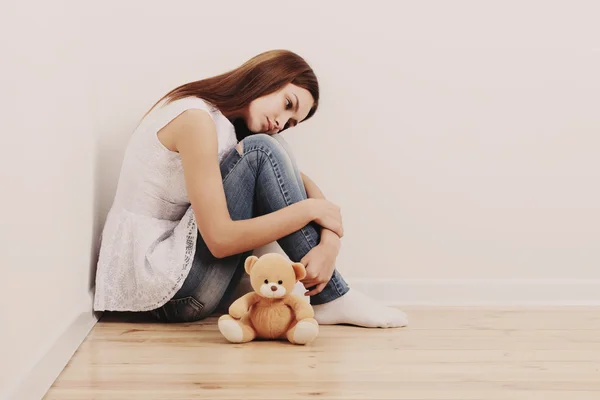 Sad κορίτσι εφήβων στο πάτωμα με το παιχνίδι — Φωτογραφία Αρχείου
