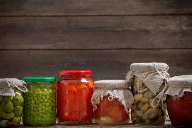 Ahşap arka plan üzerinde turşu sebzeli kavanoz