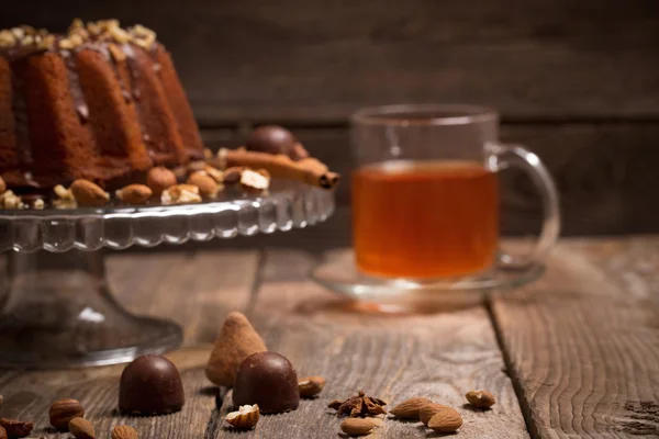 Cake, candy, nuts and cup  on old wooden background — Stock Photo, Image