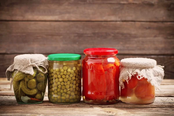 Jars with pickled vegetables on wooden background — Stock Photo, Image