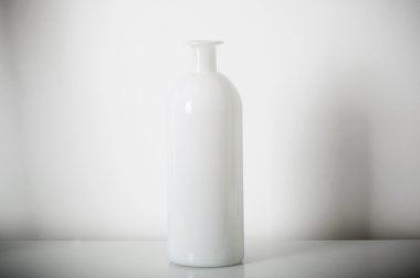 Beyaz rafındaki beyaz vazo