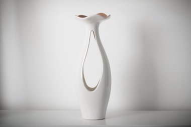 Beyaz rafındaki beyaz vazo