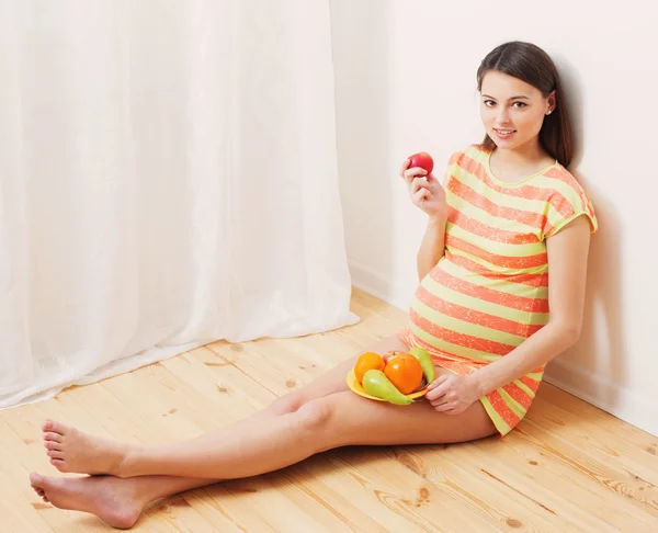 Mulher grávida comendo frutas — Fotografia de Stock