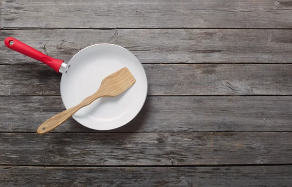 Frying pan on old wooden background — Stock Photo, Image