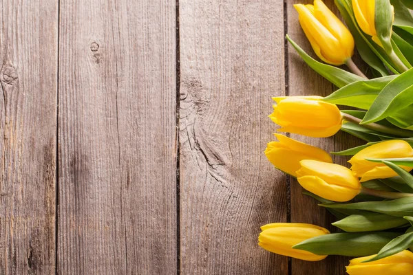 Tulipani gialli su sfondo tavolo di legno — Foto Stock