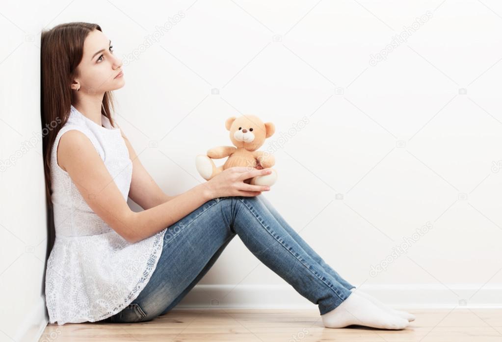 sad teen girl on floor with toy
