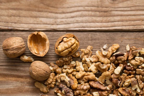 Nueces y nueces enteras sobre mesa rústica de madera vieja —  Fotos de Stock