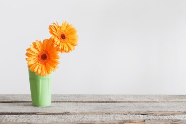 Eski ahşap masa üzerinde vazoda gerbera