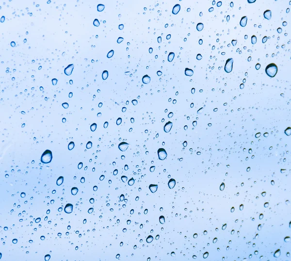 Sfondo sotto forma di gocce d'acqua sul blu Foto Stock