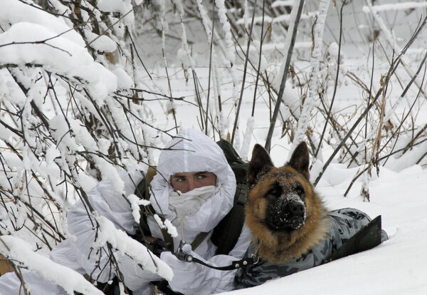Saratov, Russia December 12, 2007: A border guard with a dog in a snowy forest in the ambush on the teachings of the border department of the FSB of Russia in Saratov and Samara Region