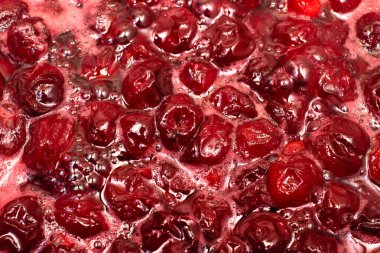 Ev yapımı kiraz reçeli pişirme işlemi. Böğürtlenleri şekerle ısıtmaya yakın görüş.