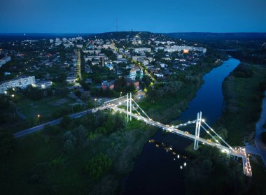Gece kasabası manzarası, nehir köprüsü ve sokak aydınlığı. Izyum kasabası, Ukrayna