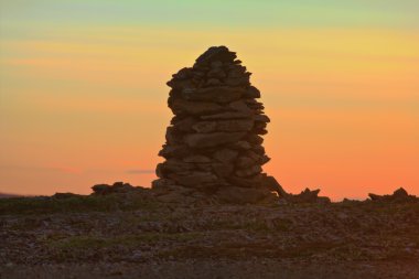 Gece yarısı, kutup gün batımında Cairn taştan inşa