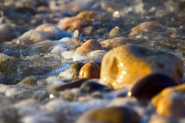 Çok Renkli Yuvarlak Çakıl Taşları Köpük Tuzlu Dalgalardan Oluşan Plaj — Stok fotoğraf