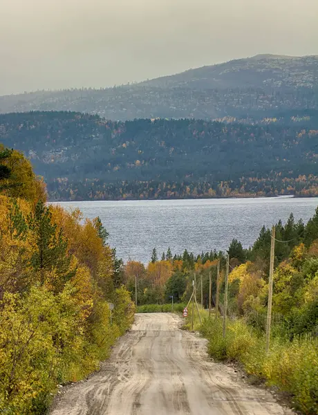 风景路线 汽车旅行 穿过秋天森林和湖区的泥泞道路 地平线上的群山 — 图库照片