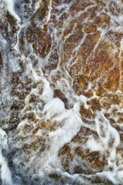 Nehir arka plana sıçrar, enerji dolu kırmızımsı kaynak suyu