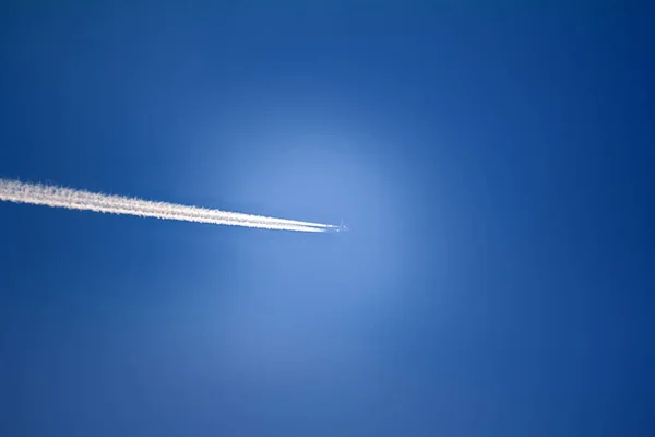 Jet airplane in sky, air routes by white vapor in flight