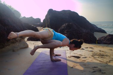 Plaj kayalarında maneviyatı geliştirmek için meditasyon ve spor