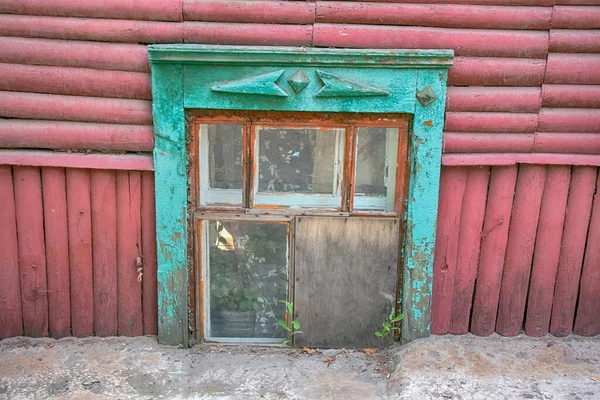 Wooden window shutters in old country house - carved window. Siberia, Altai. Window level with road