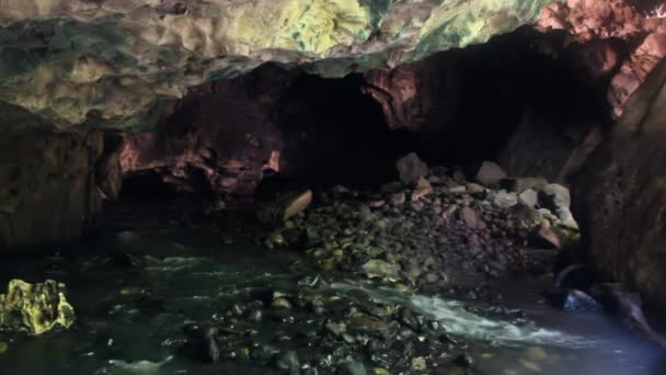 Пещерная река течет из скалы — стоковое видео