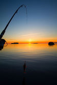 naplemente folyó sügér halászat a hajó, és egy rúd
