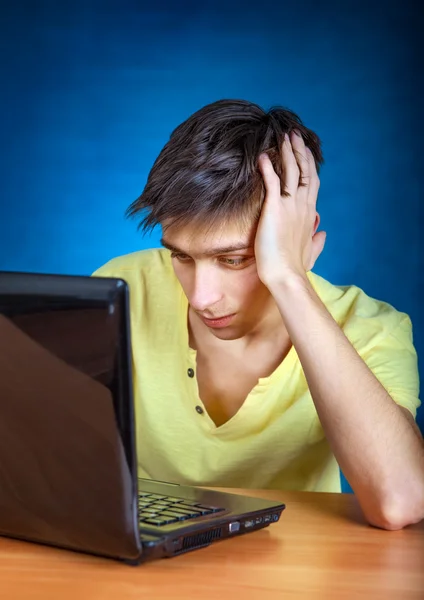 Θλιβερή νεαρός με φορητό υπολογιστή — Φωτογραφία Αρχείου