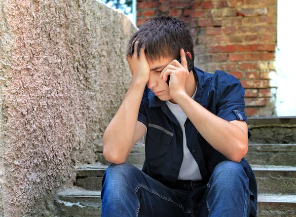 Ledsen tonåring med mobiltelefon — Stockfoto