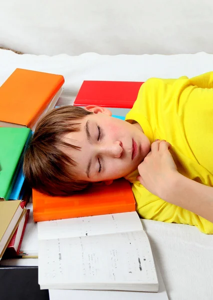 Miúdo dorme nos livros — Fotografia de Stock