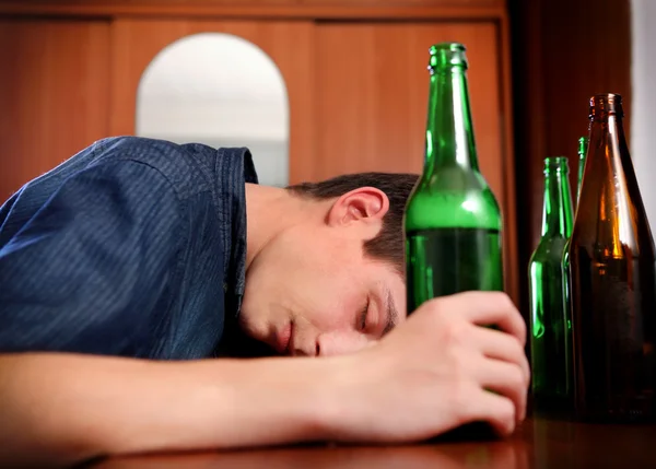 Giovane uomo dormire con una birra — Foto Stock