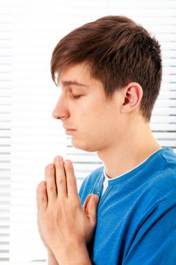 Genç adam Jalousie 'nin arka planında dua ediyor.