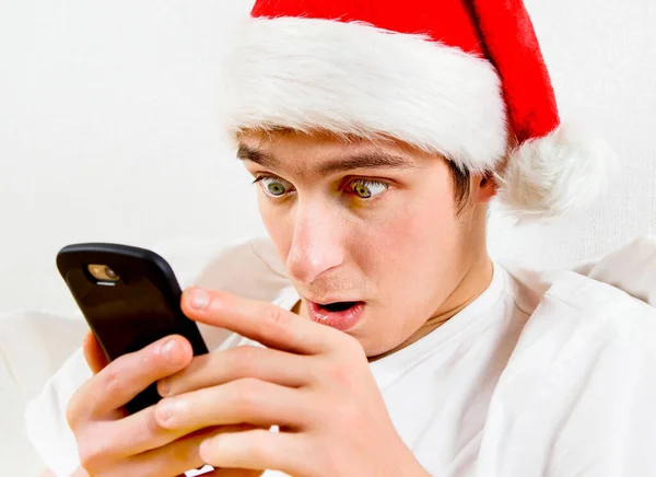 Överraskad Ung Man Santa Hatt Med Telefon Den Vita Bakgrunden — Stockfoto