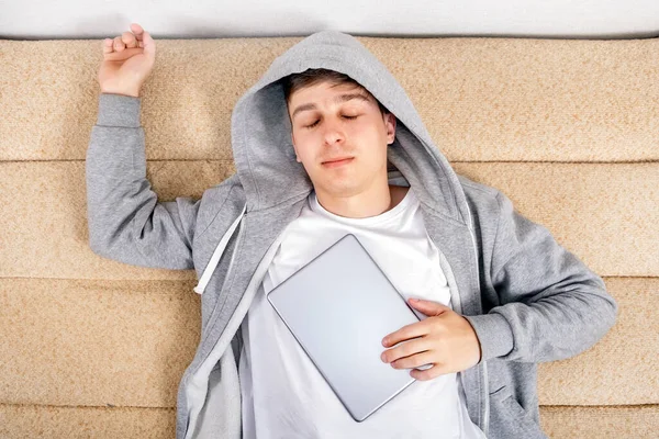 Jongeman Slapen Met Een Tablet Computer Bank Het Huis — Stockfoto