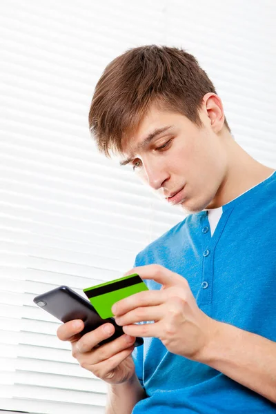 Troubled Young Man Phone Bank Card Jalousie Background — Stock Photo, Image