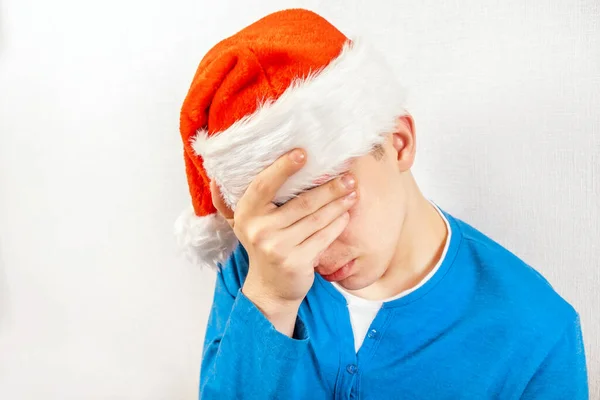 Droevige Jongeman Santa Hoed Door Muur Kamer — Stockfoto