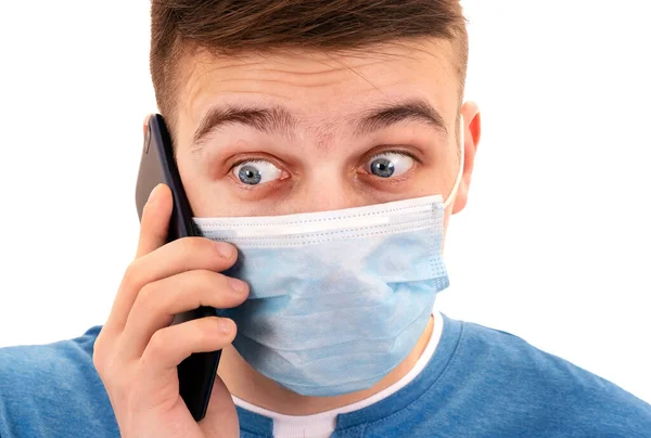 Σοκαρισμένος Νεαρός Μάσκα Γρίπης Ένα Κινητό Τηλέφωνο Απομονωμένο Στο Λευκό — Φωτογραφία Αρχείου
