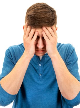 Üzgün genç adam, beyaz arka planda izole edilmiş bir baş ağrısı hissediyor.