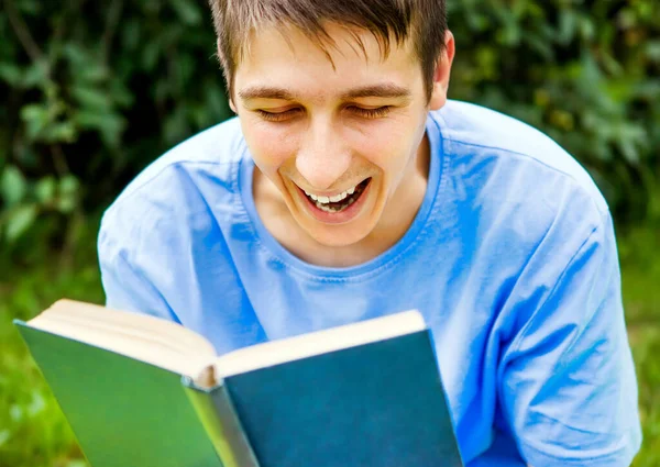 Happy Young Man Legge Libro Che Ride Nel Parco Estivo — Foto Stock