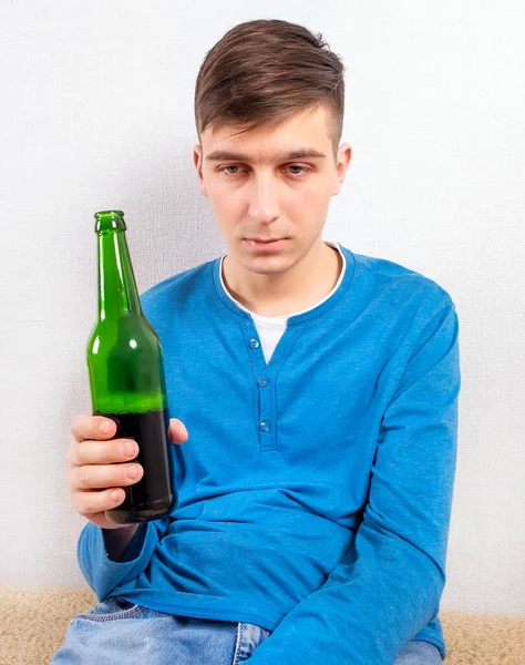 房间里的墙上挂着啤酒的可悲的年轻人 — 图库照片