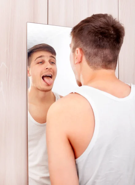 Jovem Olhando Para Reflexão Espelho Mostrar Uma Língua — Fotografia de Stock