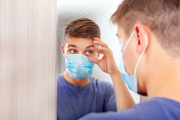 Hombre Joven Con Máscara Gripe Mirando Reflexión Espejo Comprobar Ojo — Foto de Stock